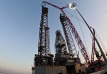 Mammoet's CC 8800-1 crawler crane in Boom Booster configuration installing rig leg extension sections at Drydocks World Dubai.