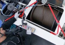 The Grove Wire Rope Cleaner cleaning and lubricating the wire rope of a mobile crane