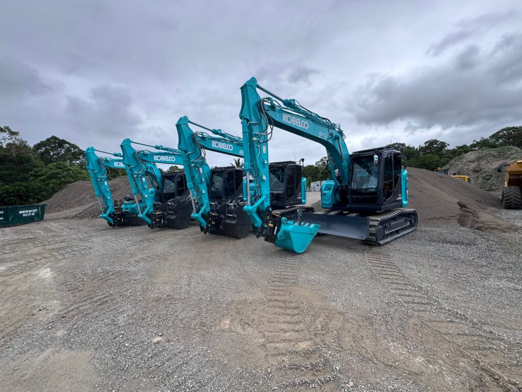 Late-model Kobelco excavators lined up in the earth gear yard, ready for civil dry hire mobilisation.