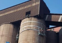 Build-Up Is a Production Problem, Not Just a Cleaning Job High-pressure water jetting on a silo at a mining operation
