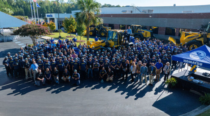 Employees gather with Komatsu wheel loaders at the Newberry Manufacturing Operation's 25th anniversary celebration, October 2, 2026