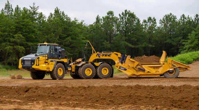 One Truck, Two Jobs: Komatsu Clears the K-Tec Scraper to Ride Behind Its HM460-6 The K-Tec 1237 ADT scraper towed by a Komatsu HM460-6 articulated dump truck